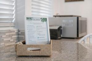 uma caixa com um cartaz em cima de um balcão em LAST MINUTE OPENING! Delightful & Spacious 2BR2BA Apartment Available AC em Kailua