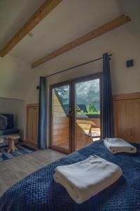 a bedroom with a bed and a sliding glass door at ApartHost Zakopiańskie Chaty in Kościelisko