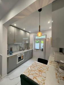 a kitchen with a table and a dining room at Apartament Latarników Stilo in Sasino