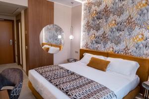 a bedroom with a large bed with a floral wall at Hotel Liola' in Castrocielo