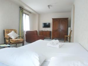 a bedroom with a white bed and a living room at Classic House in Argentat