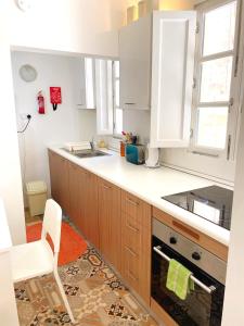a kitchen with wooden cabinets and a white counter top at MoCo, modern comfort in historic city of Senglea in Senglea