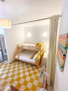 ein kleines Zimmer mit einem Etagenbett und einem karierten Boden in der Unterkunft MoCo, modern comfort in historic city of Senglea in Senglea