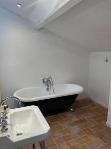 a bathroom with a black and white tub and a sink at Maison d'Orange - La Pinede in Saint-Tropez