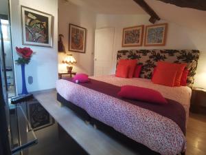 ein Schlafzimmer mit einem großen Bett mit roten Kissen in der Unterkunft Chambre au calme de la campagne in Le Vernet