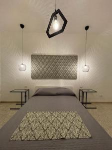 a bedroom with a bed with two tables and two lights at Al Cortile in Reggio di Calabria