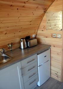 a kitchen in a tiny house with wooden walls at Arbor Hills in Gransha