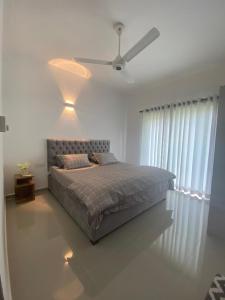 una camera con letto e ventilatore a soffitto di 3 Bedroom Apartment, Ariyana Resort ad Athurugiriya