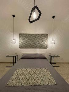 een slaapkamer met een groot bed en 2 tafels bij Al Cortile in Reggio di Calabria