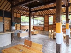 Puri Sadewa Balangan في جيمباران: غرفة خشبية كبيرة مع طاولات وكراسي خشبية