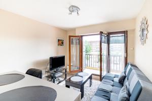 a living room with a couch and a tv at Le Grand Cap in Villers-sur-Mer