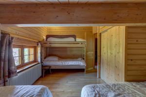 a bedroom with two bunk beds in a wooden cabin at La Forge in Manigod