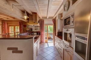 a large kitchen with wooden ceilings and a counter top at La Forge in Manigod