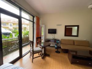 sala de estar con sofá y mesa en 3 Pax Charming Foggy Cold Breeze, Cozy Gardenville Hotel, en Baguio