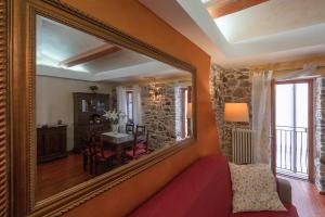 a mirror in a room with a table and a dining room at LA CASETTA - Mon Petit Chalet in Miranda