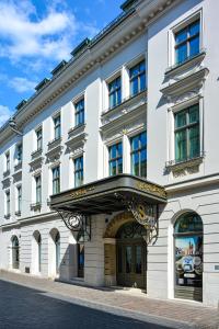 a white building with a sign on the front of it at Hotel Saski Krakow Curio Collection by Hilton in Kraków