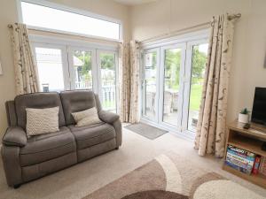 - un salon avec un canapé et une grande fenêtre dans l'établissement Waterside Lodge, à Carnforth