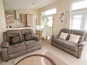 - un salon avec deux chaises et un canapé dans l'établissement Waterside Lodge, à Carnforth