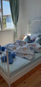 Una cama blanca con almohadas azules. en Къща за гости Свети Йоан Кръстител, en Varna
