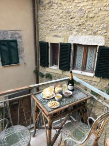 a table with food and a bottle of wine on a balcony at La Casa nel Castellare in Campiglia dʼOrcia