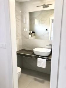 a white bathroom with a sink and a toilet at Hotel B&B CHAMBERLAIN in Hvar