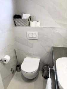 Baño blanco con aseo y lavamanos en Hotel B&B CHAMBERLAIN, en Hvar