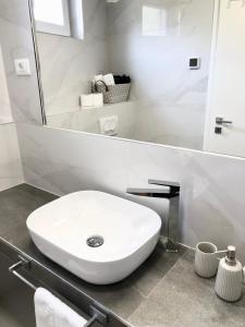 a white bathroom with a sink and a mirror at Hotel B&B CHAMBERLAIN in Hvar