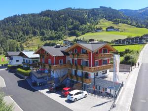 een groot huis met een auto geparkeerd op een parkeerplaats bij Elto Appartements Chalet in Kaprun