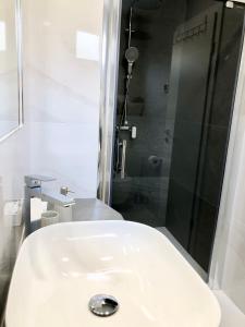 y baño con ducha y lavabo blanco. en Hotel B&B CHAMBERLAIN, en Hvar