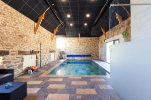 una piscina en una habitación con una pared de ladrillo en Les Thermes du Liet, en Plédèliac
