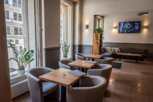 a restaurant with tables and chairs and a couch at Hotel Brixen in Prague