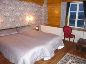 a bedroom with a large bed and a red chair at La Cameline in Plougasnou