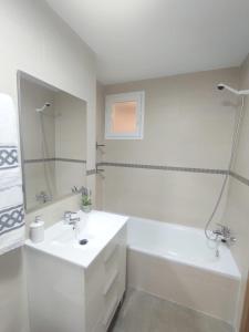 uma casa de banho branca com um lavatório e uma banheira em ALMIJARA em Vélez-Málaga