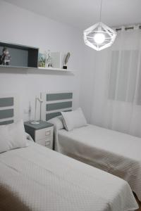 a bedroom with two beds and a light fixture at ALMIJARA in Vélez-Málaga