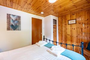 a bedroom with a bed in a room with wooden walls at Bracken Lodge 7 with Hot Tub in Belladrum +14 photos