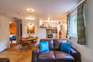 a living room with a leather couch and a table at Bracken Lodge 7 with Hot Tub in Belladrum