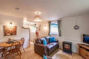 a living room with a leather couch and a table at Bracken Lodge 7 with Hot Tub in Belladrum