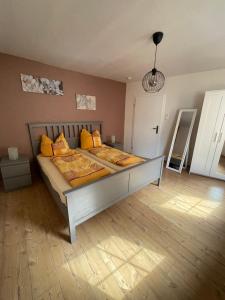 1 dormitorio con 1 cama grande con almohadas amarillas en Relaxen im alten Winzerhaus Fewo OG, en Rech