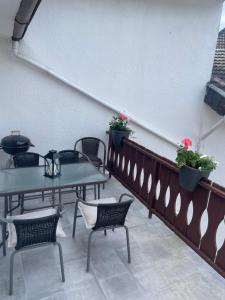 un patio con mesas, sillas y flores en Relaxen im alten Winzerhaus Fewo OG, en Rech