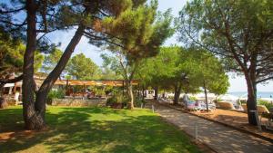 un parque con árboles y gente sentada en bancos en Nice-Comfort-Lux Apartment 95m2 near the beach en Medulin