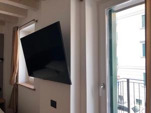 einen Flachbild-TV an einer Wand neben einem Fenster in der Unterkunft VILLA CARLOTTA GRADO in Grado