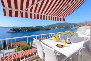 a table and chairs on a balcony with a view of the water at Sunset Apartment in Zaton