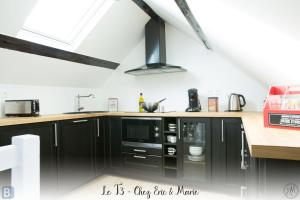 オンフルールにあるLes Maisons de Maje - Le T2-T3のキッチン(黒いキャビネット、黒い電子レンジ付)