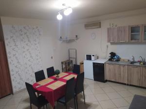 a kitchen with a table and chairs in a kitchen at Pingpong Apartman in Soltvadkert