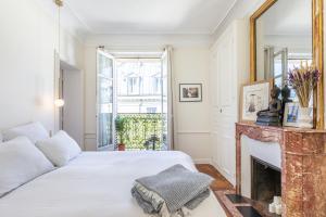 sypialnia z łóżkiem i kominkiem w obiekcie Exceptional Haussmannian apartment- Heart of Paris w Paryżu