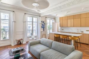 a living room with a couch and a table at Exceptional Haussmannian apartment- Heart of Paris in Paris