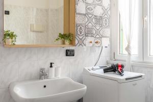Baño blanco con lavabo y espejo en [VILLA LECCO] FREE Wi-Fi, Parking & Bike Service, en Lecco