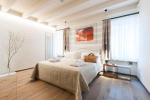 a bedroom with a bed, a desk, and a painting on the wall at Verona Suites in Verona