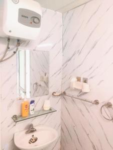 a white bathroom with a sink and a mirror at Hanowood Homestay - Renovated since June 2026 in Hanoi +134 photos