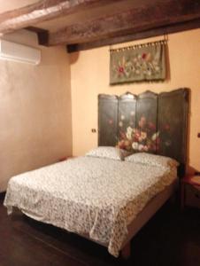 ナポリにあるAppartamento centro storico Napoliのベッドルーム1室(ベッド1台付)が備わります。壁には絵画が飾られています。